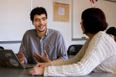 N A U student, Isaiah Raspet, smiles while chatting with his professor.