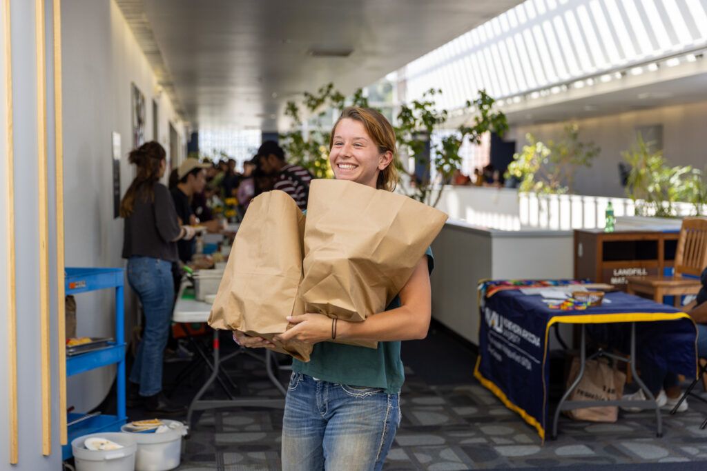 An N A U student volunteering at Louie's Cupboard to help classmates and minimize food waste.