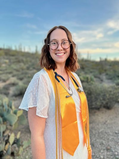 N A U graduate, RN Rachel Stearns, poses and smiles for a picture.