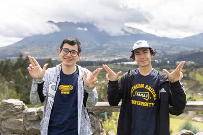 An N A U Honors College students smile while doing the Lumberjacks hand symbol while in Ecuador.