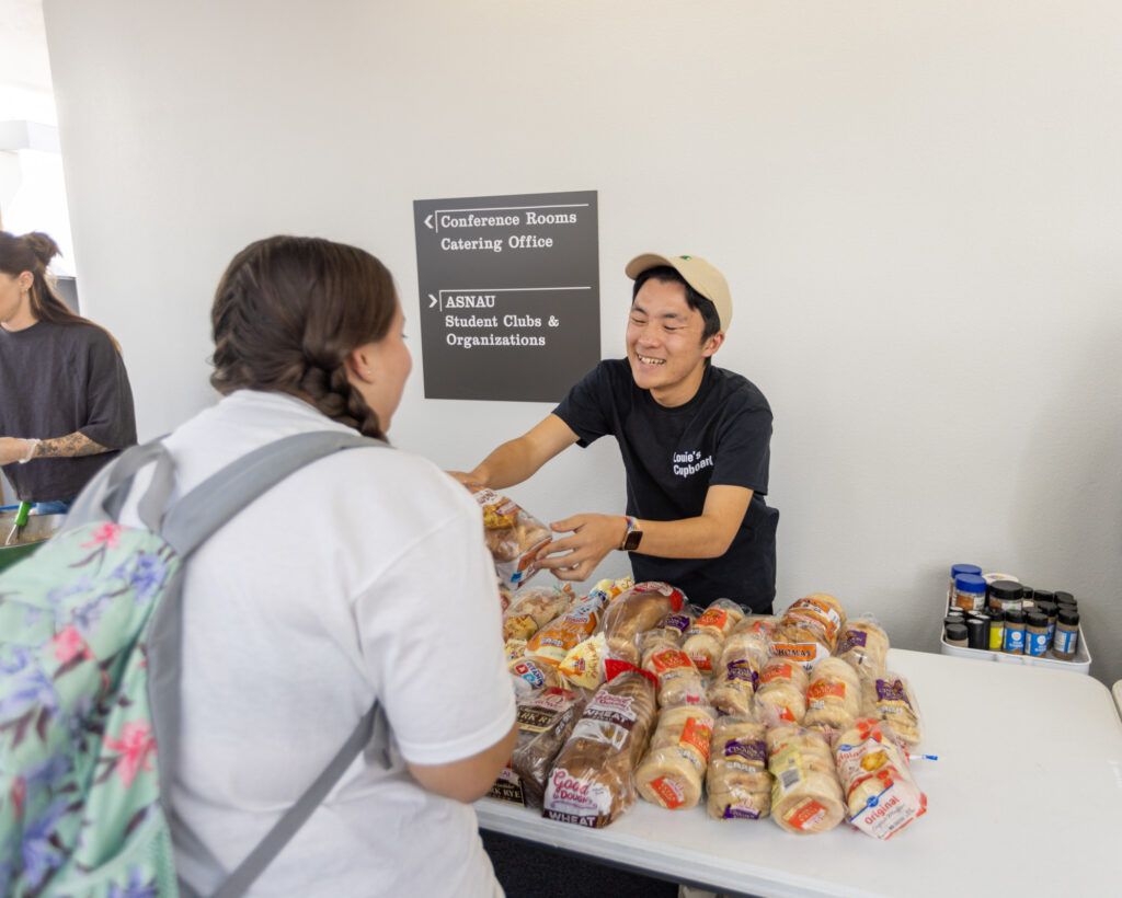 Student receiving bread from LOUIE's Cupboard food distribution program.