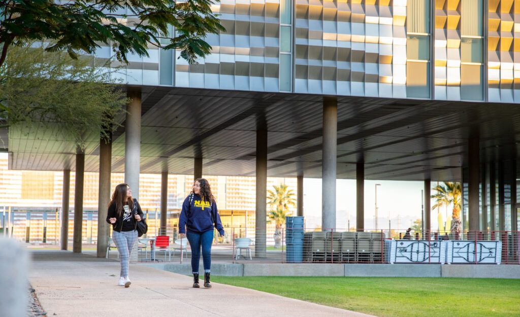 Students happily chat at the N A U Yuma Campus on a sunny day.