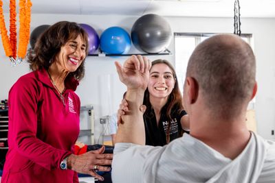 An N A U Physical Therapy student assists a patient with the help of her professor.