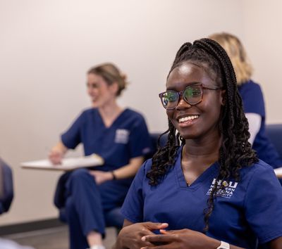 An N A U College of Nursing student smiles while talking to classmates on the Flagstaff Campus.