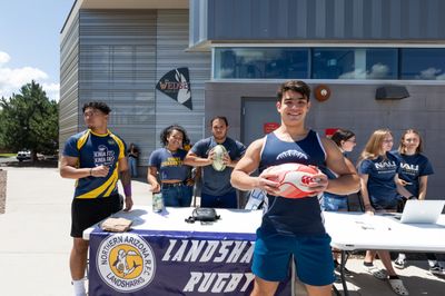 Several students standing around a booth advocating for their club at N A U's Club Fair.