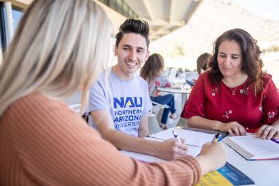 Happy N A U statewide students sitting at a table.